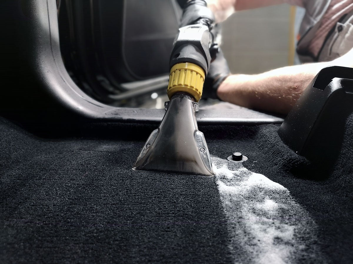 Auto interieur dieptereiniging - vloerbekleding in auto met professionele shampoo machine reinigen.